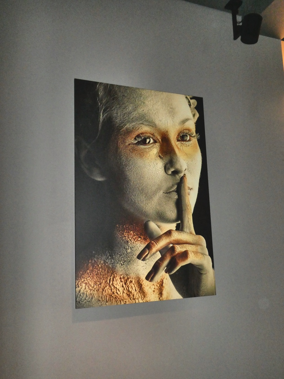 Wandbild im Le Théâtre: Porträt mit dem Finger auf den Lippen